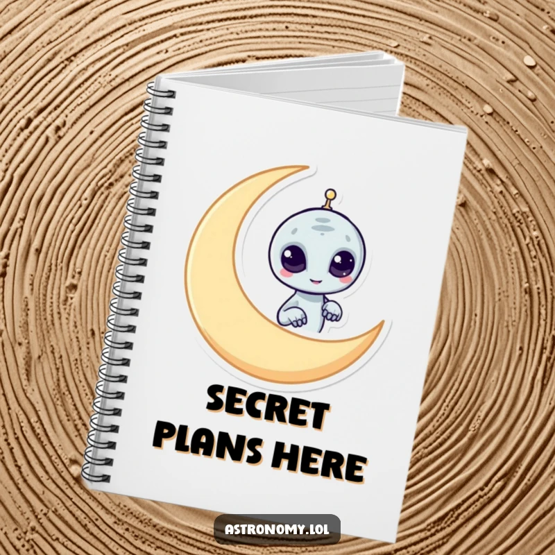 Funny alien notebook featuring a mischievous character peeking from behind a crescent moon, ideal for journaling with humor.